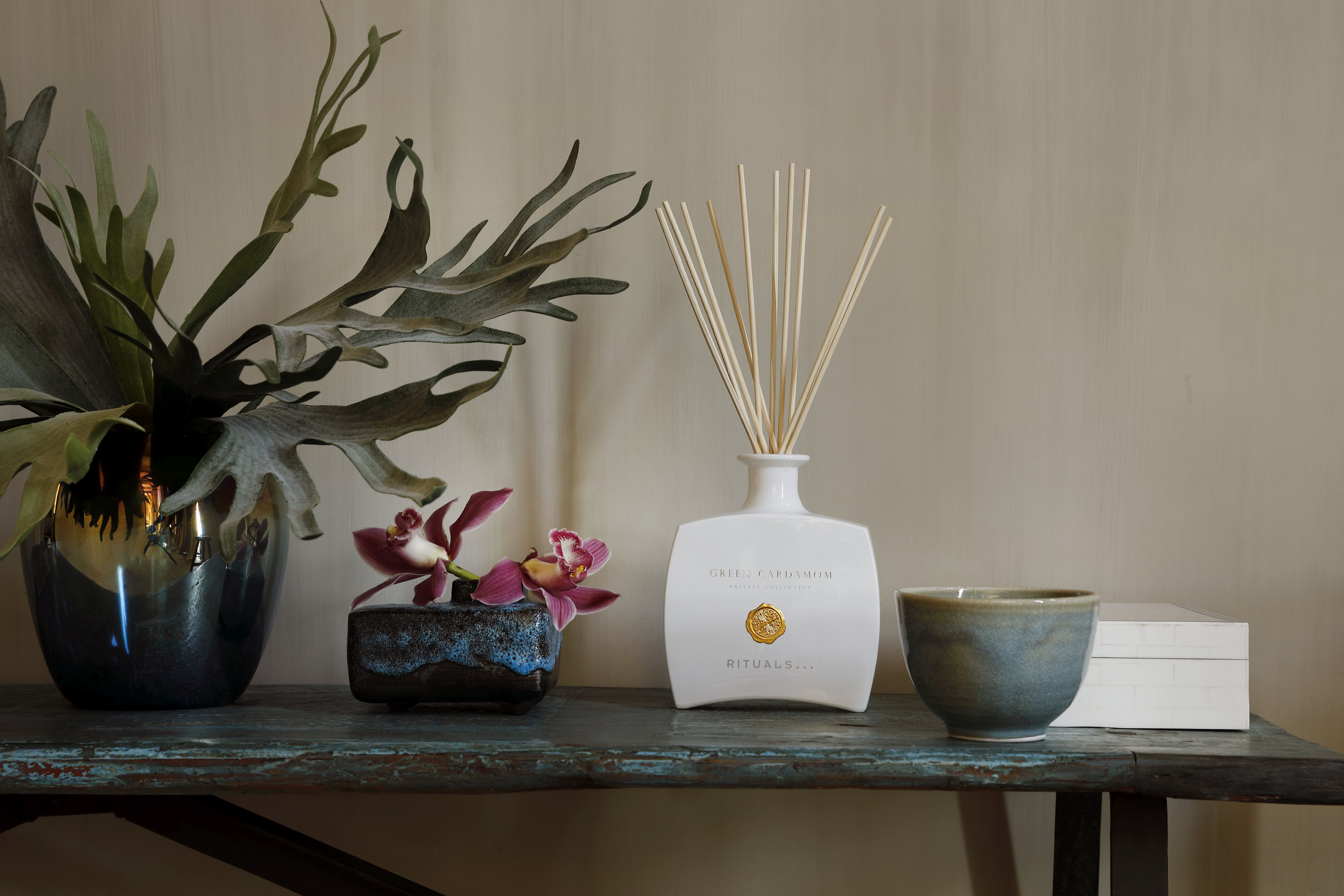 Rituals Private Collection fragrance sticks on a shelf with plants, a cup, and a decorative box.